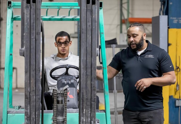 VersAbility TECH instructor coaching a student seated on a forklift during hands-on training.
