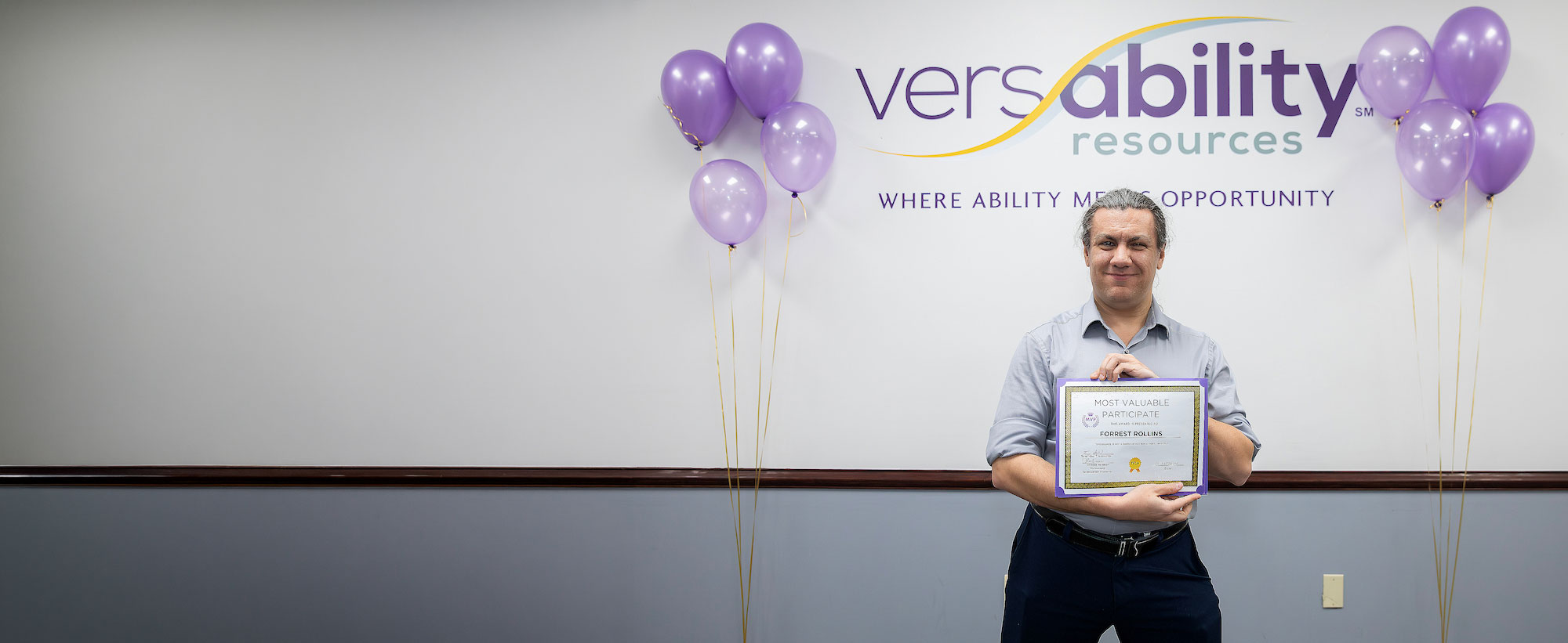 Graduate with certificate from the VersAbility TECH AbilIT program