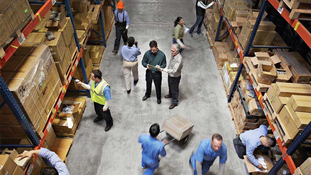 1. Warehouse workers organize and handle numerous boxes in a busy storage environment.